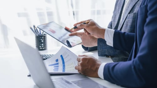 Two people reviewing financial data